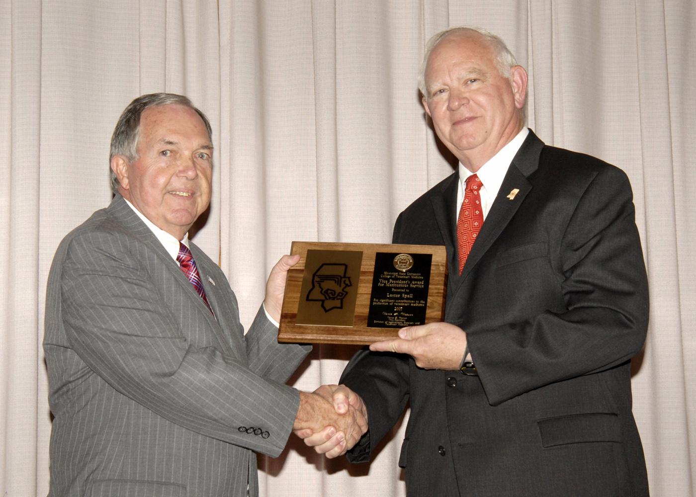 Mississippi State University's Vice President for the Division of Agriculture, Forestry and Veterinary Medicine Vance Watson, left, presents Dr. Lester Spell with the Vice President's Pegasus Award at "All College Day," held recently at MSU's College of Veterinary Medicine. Spell studied pre-veterinary medicine at MSU before going to Auburn to earn a doctorate of veterinary medicine in 1968. He has served as Mississippi's Commissioner of Agriculture and Commerce since 1996. (Photo by Tom Thompson/MSU Ag Com