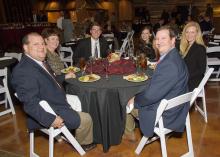 Six guests pause for a photo during a formal dinner.