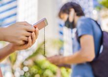 People wearing face masks holding cell phones