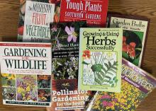 Garden-themed books are spread on a table.