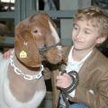 Tate County 4-H member Canan McKellar, age 9, spends a moment with his grand champion goat before entering the arena at the Dixie National Sale of Junior Champions. The goat, which was the champion mediumweight goat, brought a sale record $80 per pound for a total of $7,200.