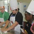 From left, Lamar Land, Ben Barker and Murritta Lane work as a team kneading dough to make bread. "Fun with Food" participants made many nutritious meals during their week at camp. (Photo by MSU Office of Ag Communications)