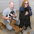 Mississippi State University veterinary medical student Wade Bowers of Memphis and Aberdeen animal shelter manager Astrid Peterson play with several of the dogs at the facility. (Photo by Tom Thompson)