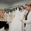 Jennifer Burt, left, and Christine Barker, of Christine's Couture in Starkville, examine the intricate patterns of beading and lace that commonly adorn authentic designer wedding gowns. Handsewn embellishments like these are never seen on counterfeit dresses. (Photo by Scott Corey)