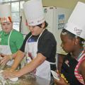 Lamar Land, Ben Barker and Murritta Lane work as a team kneading dough to make bread at the annual "Fun with Food Camp." Land, Barker and Lane attended the camp in 2009 and had the opportunity to make many nutritious meals and learn more about the culinary arts. (Photo by Karen Templeton)