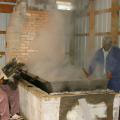 Hosea Brown, right, cooks down sugar cane syrup to molasses the old-fashioned way over a wood fire in his family business in Jefferson Davis County. Family friend Joe Norwood helps with the work at My Paw Paw's Ole Fashion Molasses in New Hebron. (Photo by Prentiss Headlight/Shirley Burnham)