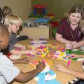 Crossgates Methodist Children's Center after-school students from left Jalen Ballard, Hardy Lewis and Layton Levingston play a compound word matching game with Tara Dickerson, a technical assistant with Mississippi State University's Out-of-School Project. (Photo by MSU School of Human Sciences/Alicia Barnes)