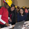 I-Wei Chu, with Mississippi State University's Institute for Imaging and Analytical Technologies, helps Biloxi Junior High School eighth-grader, Danaisha Cherry, and her mother, Lydia Cherry, look at some images with a scanning electron microscope during the Pathways2Possibilities career expo Nov. 13. More than 6,000 eighth-graders participated in the two-day event at the Mississippi Coast Coliseum and Convention Center in Biloxi. (Photo by MSU Ag Communications/Kat Lawrence)