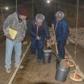 Okolona poultry grower Joe Ellis, left, watches as Mississippi State University poultry scientists Morgan Farnell, center, and Tom Tabler dig litter samples from the floor of one of his broiler houses on March 6, 2014. MSU researchers are collecting samples from houses across the state to update fertility data. (Photo by MSU Ag Communications/Linda Breazeale)