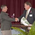 Mississippi State University Extension Service Director Gary Jackson, right, presents Forrest County Agricultural High School Superintendent Jerry Morgan with an MSU cowbell April 8, 2014, to mark the beginning of a partnership between the school and university. The Extension Service loaned the school an interactive video system that allows students, faculty and staff to attend Extension educational programs. (Photo by MSU Ag Communications/Kat Lawrence)