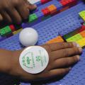 A child uses colorful LEGO bricks at a 4-H Robotics competition.