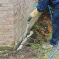 A pesticide technichian applies a termite treatment around a home foundation.