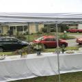 From inside a tent, cars can be seen lined up on the street.