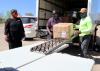 Three volunteers unload boxes from an 18-wheeler.